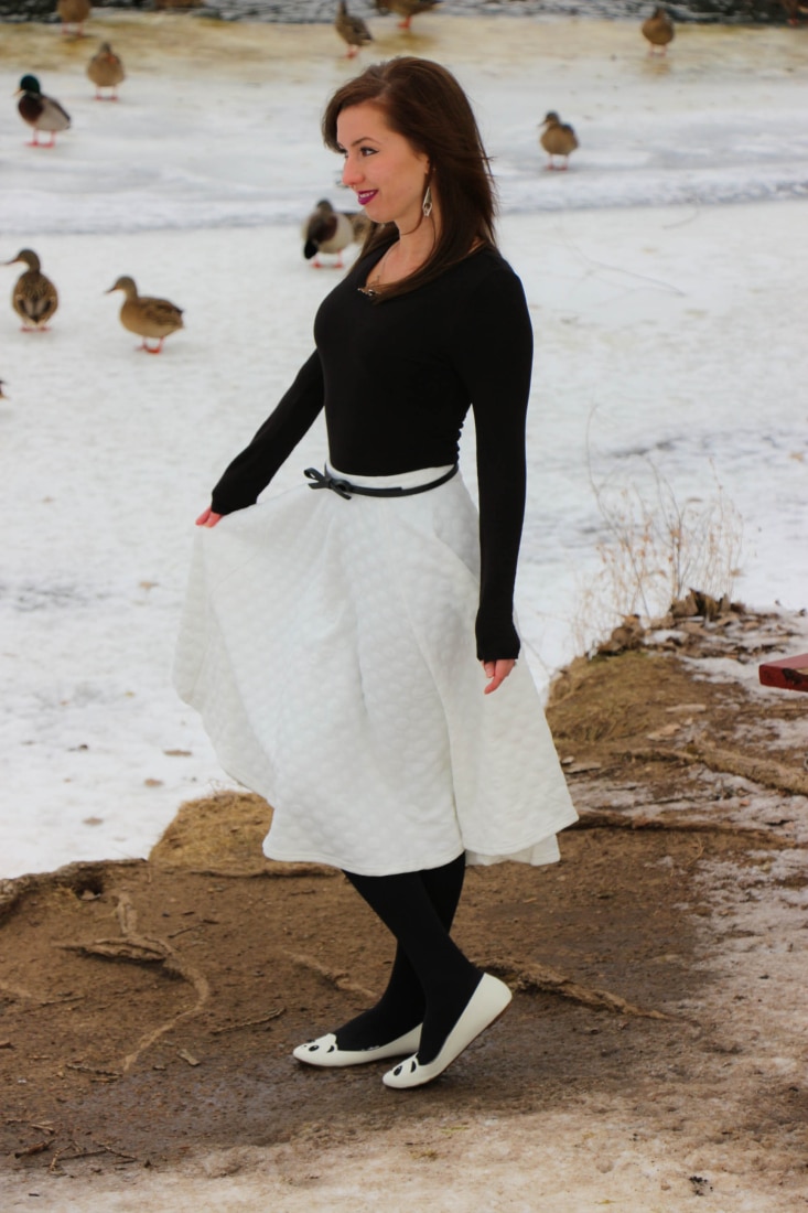 Lindsey wearing a white midi skirt paired with tights and white flats