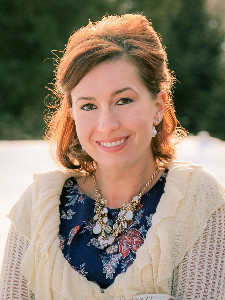 An image of Lindsey of Have Clothes, Will Travel before her eyelash extensions. She's wearing natural makeup and is smiling at the camera.