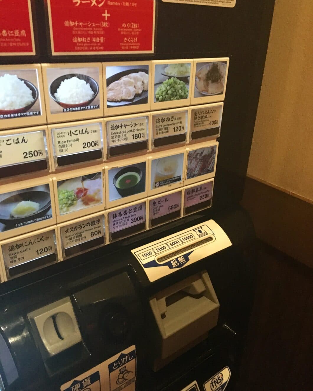 A Japanese food vending machine features small images of different dishes, from rice to means, ramen, and more.