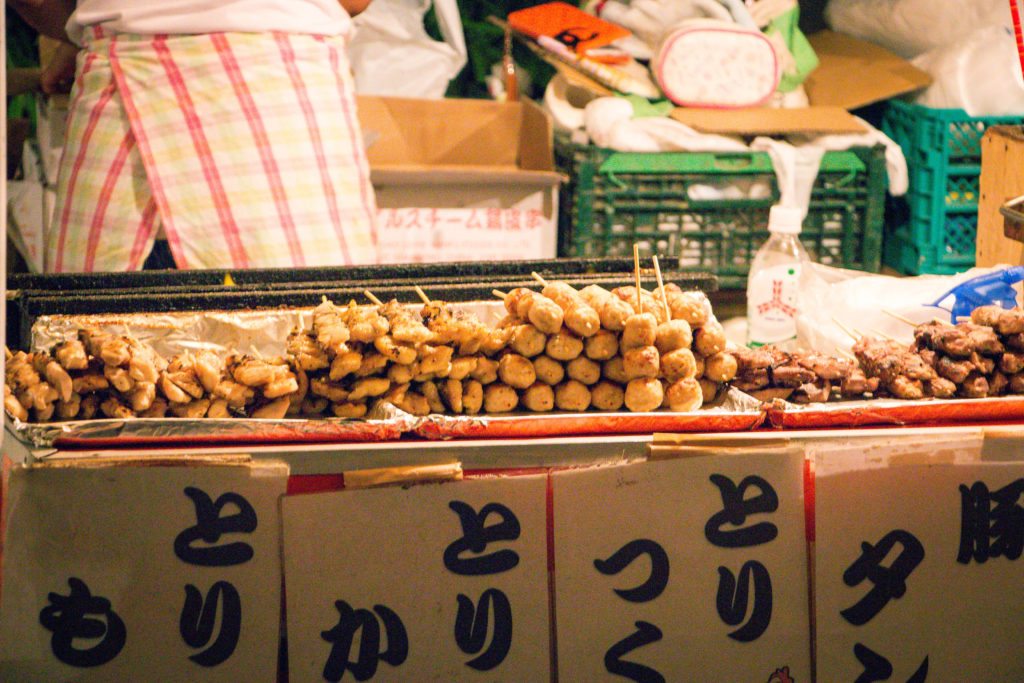 Stacks of skewered food ready for hungry customers at a Japanese street food stand.