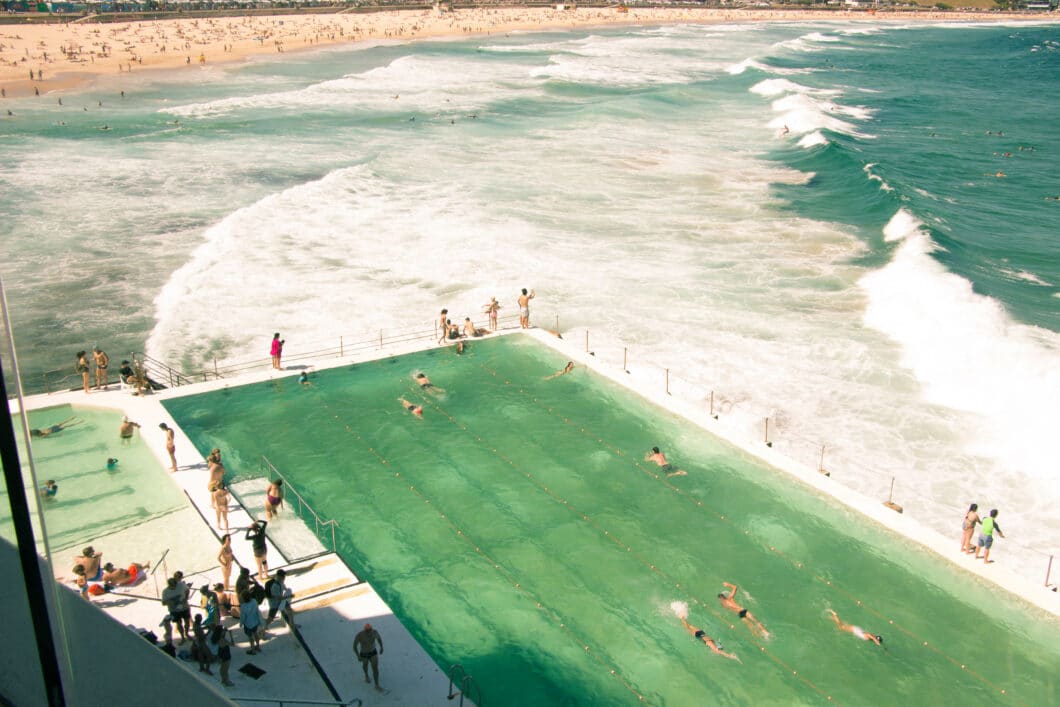 Visitors swim in a large pool overlooking the Pacific Ocean and Bondi beach in Sydney, Australia.