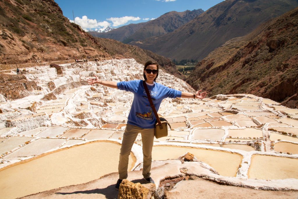 A woman standing on top of a salt flat in peru.