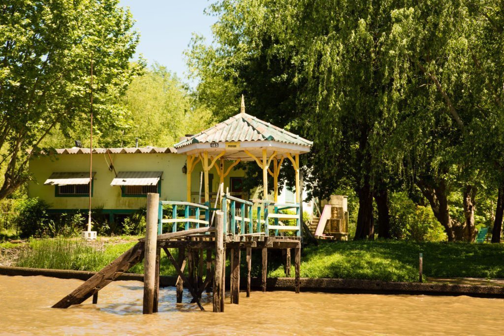 A summer home that can only be reached by boat with a wooden bridge in front of it on the Tigre Delta