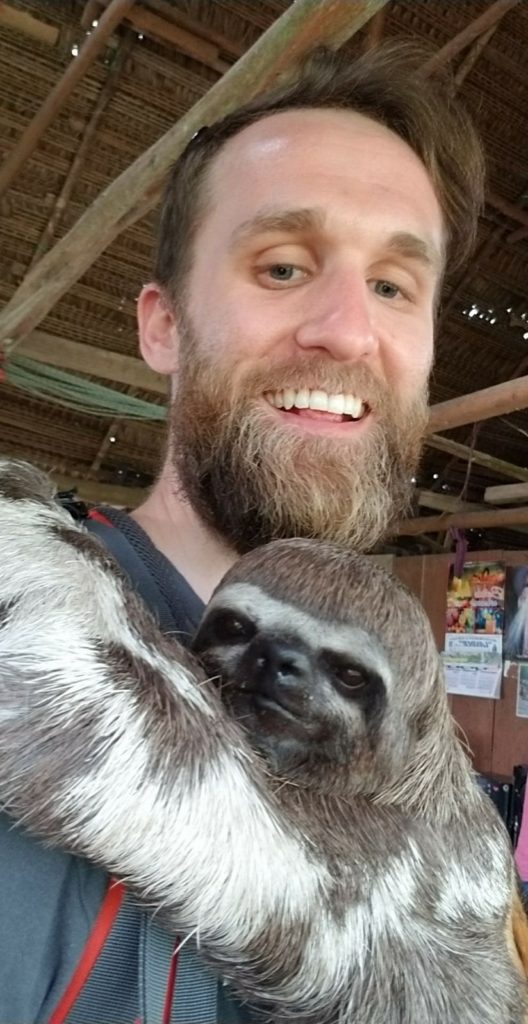 The cutest selfie of my husband hugging a sloth in an Amazon village 