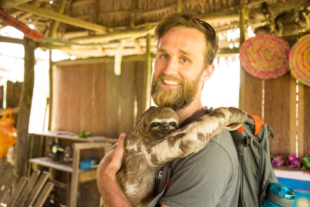 My husband hugging a sloth in our visit to a village in Amazon 