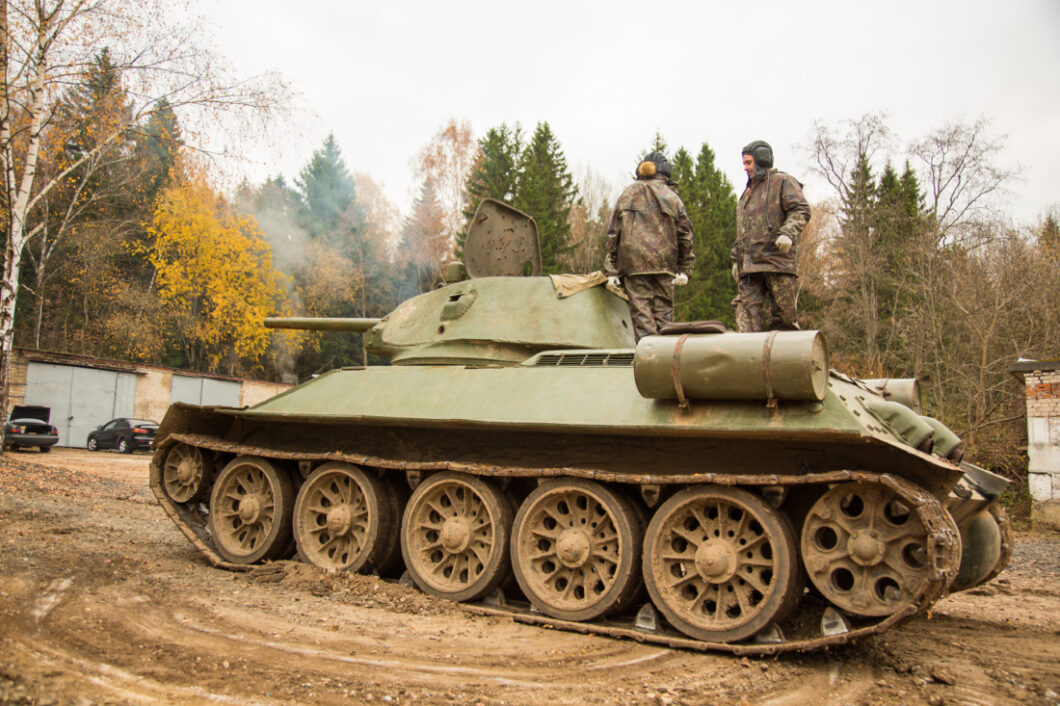 Two men stand on top of an old Soviet war tank. You can take a ride in this war-era tank as a fun and unique thing to do in Moscow.