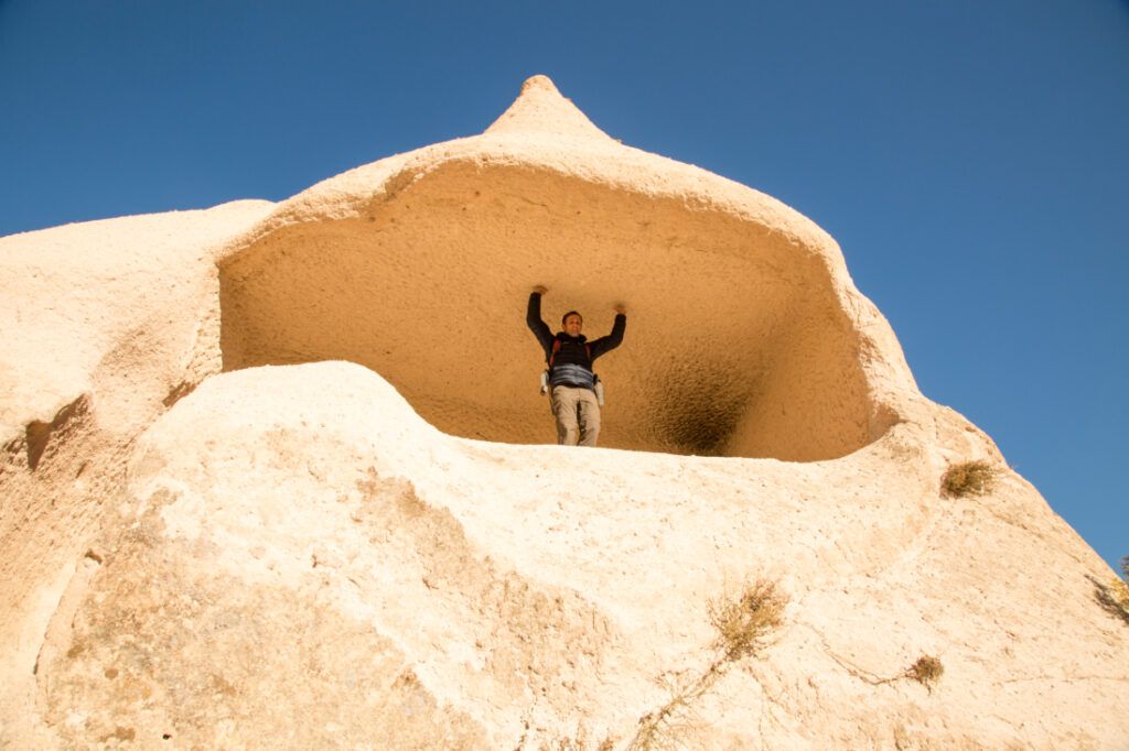 A man standing on top of a rock formation.