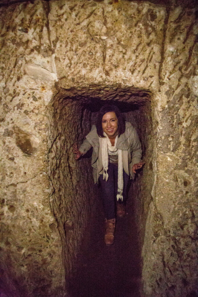 A woman standing in a stone tunnel in Derinkuyu Underground City.