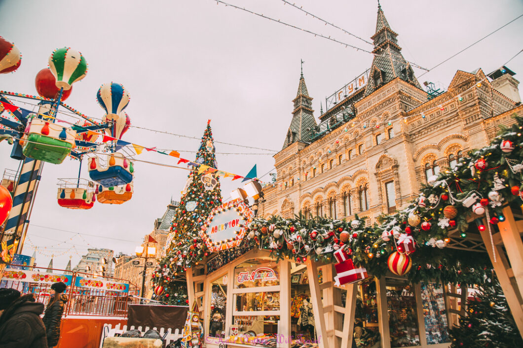 Stalls filled with Christmas decorations at the Moscow Christmas Market, with the Russian Embassy building in the background.