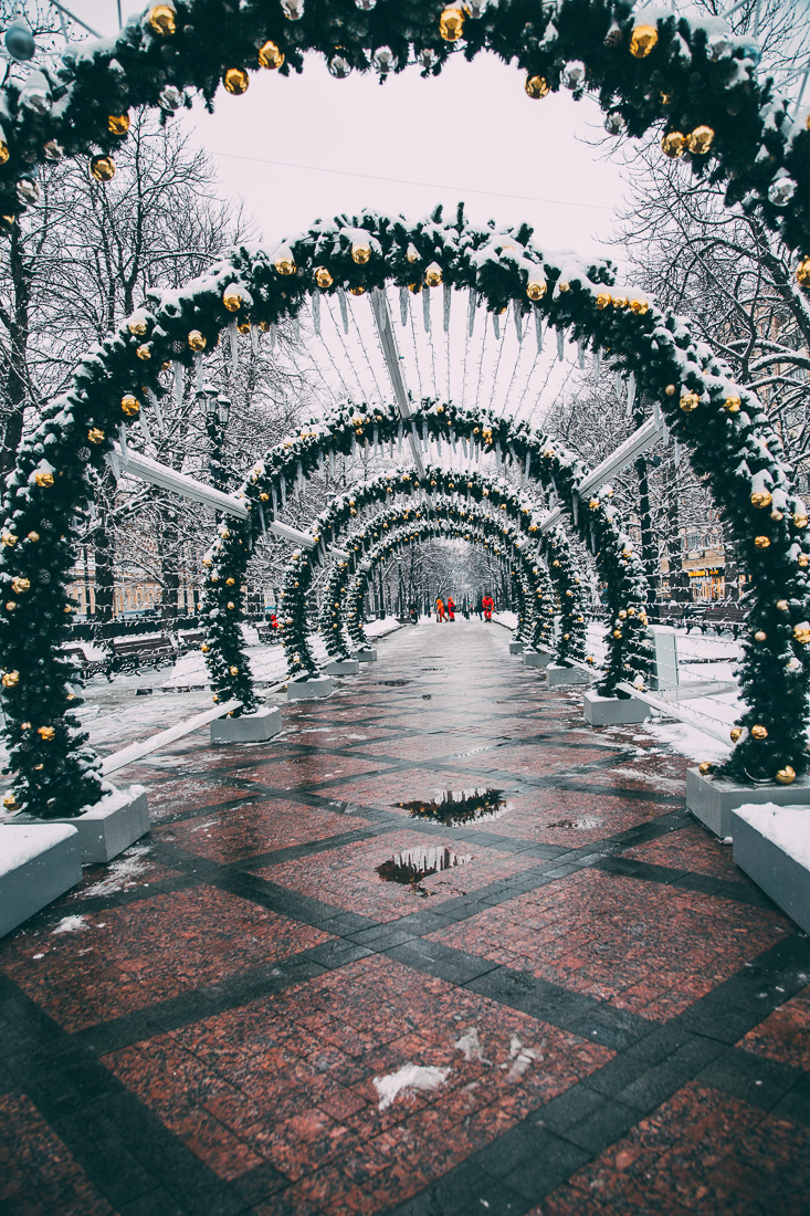 A tunnel of garland-covered archways on a snowy day in Moscow, Russia.