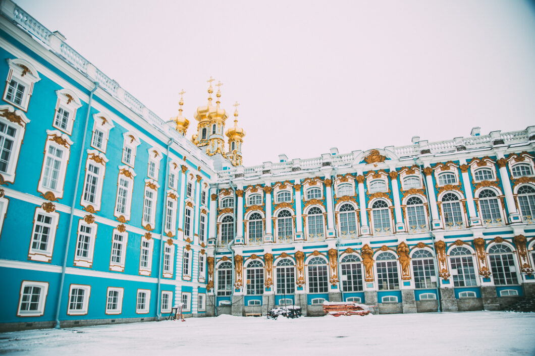 The exterior of Catherine Palace is a stunning turquoise blue color with white and gold trim and hundreds of windows. 