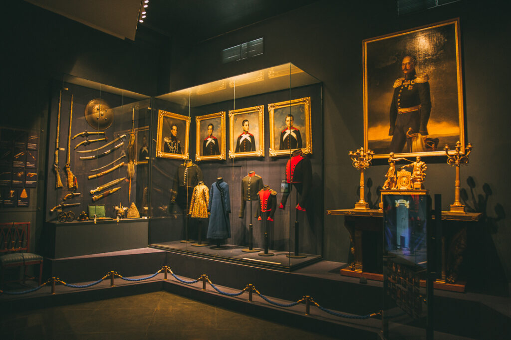 A display of historical artwork and artifacts inside a darkly-painted room at Catherine Palace.