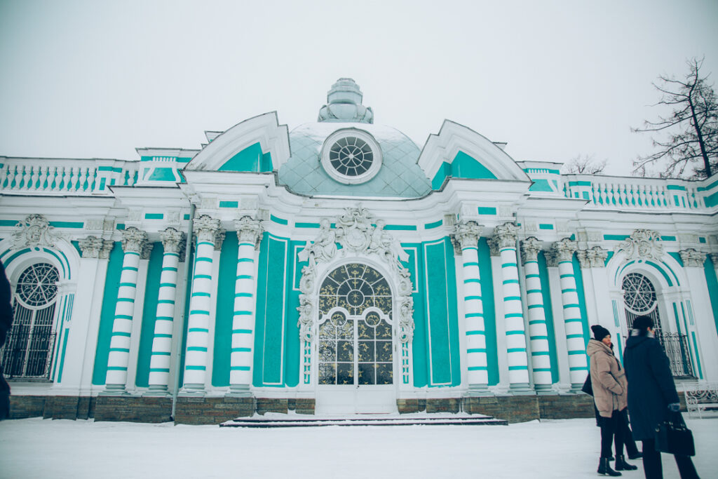 The exterior of a turquoise and white building in Russia, surrounded by a blanket of fresh snow.
