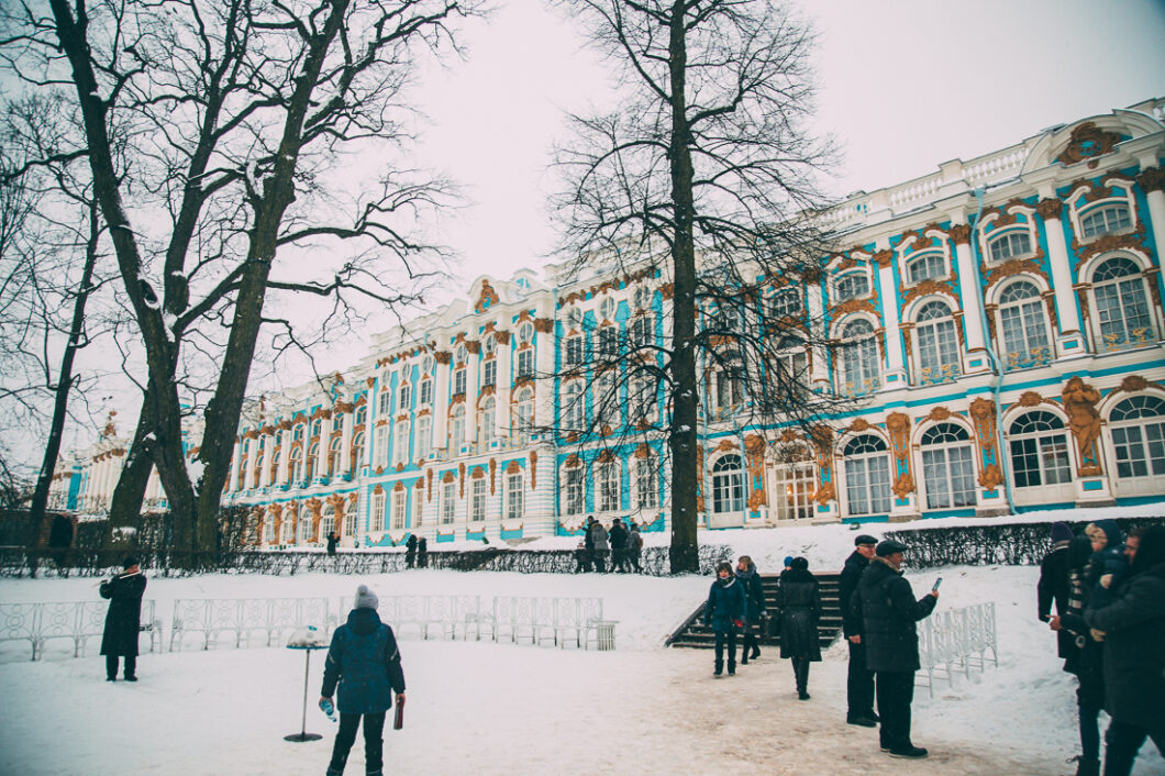 Tourist mill about in the snow-covered square outside of Catherine's Palace during a Russian winter.