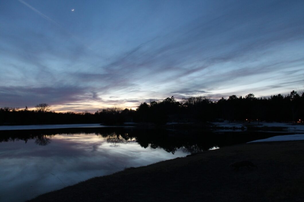 A picturesque evening sky at dusk, overlooking a quaint lake in Nebraska.