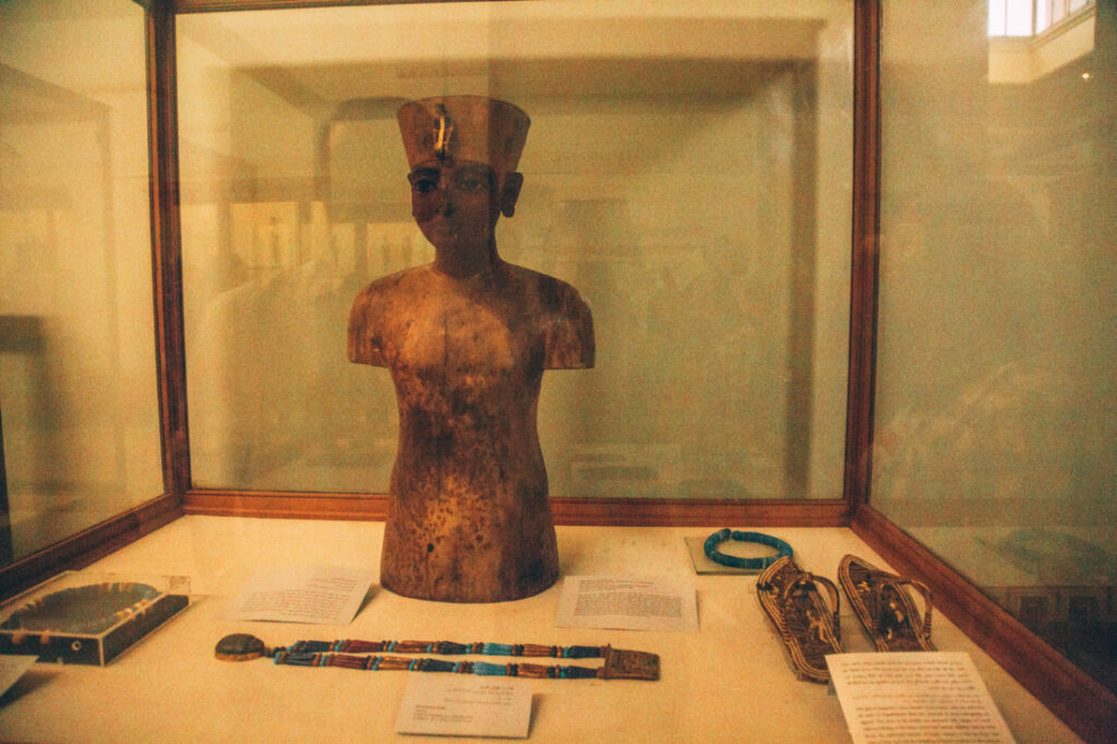 A small mannequin sits front and center in a display case, surrounded by pieces of King Tut's jewlery and information cards.