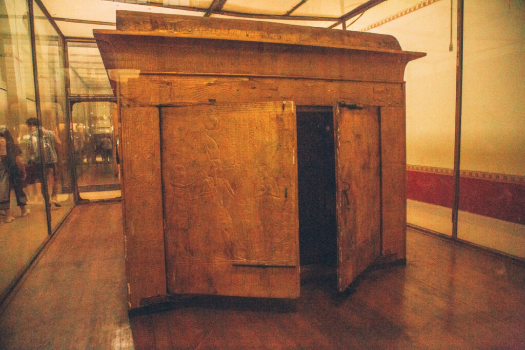 The side opening of one of King Tut's sarcophaguses, displayed inside a large glass display case at the Egyptian Museum.