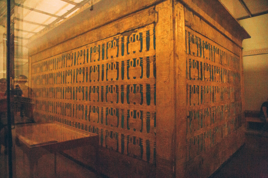 One of King Tut's sarcophaguses displayed in a large glass case at the Egyptian Museum.