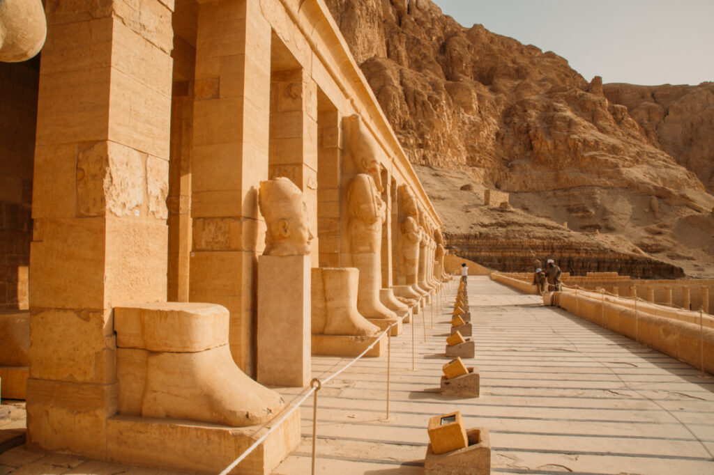 Ancient statues line the pillars outside the front of the Temple of Hatshepsut, outside of Luxor, Egypt.