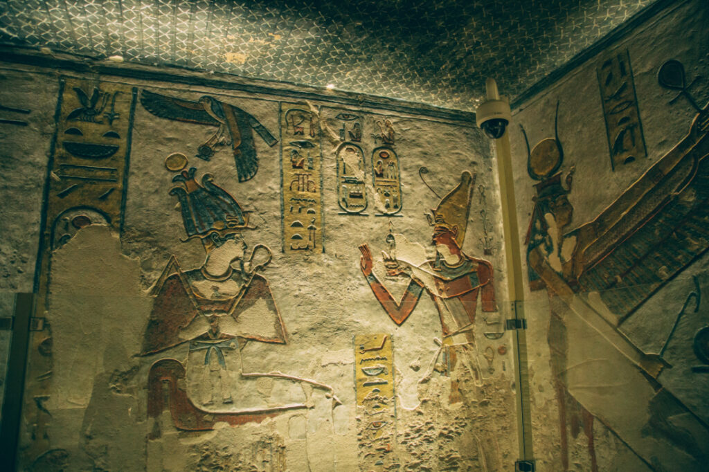 A corner of a tomb, filled with ancient artwork of Egyptian priests and pharaohs. 