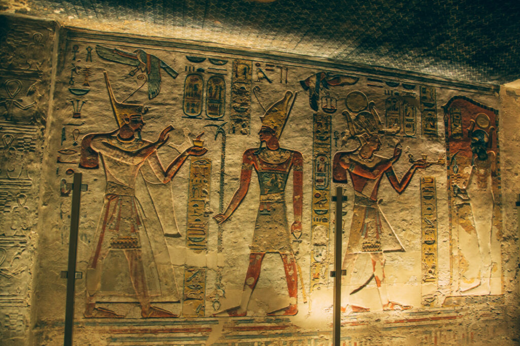 Ancient art carved and painted onto stone walls inside a tomb at the Valley of the Kings depicts Egyptian Pharaohs.