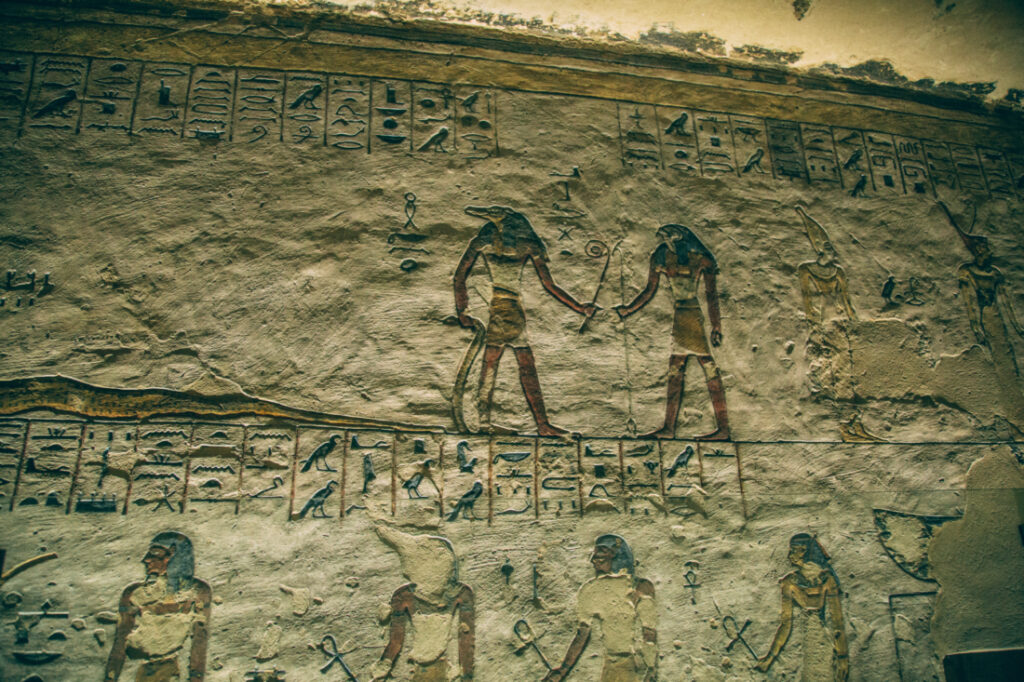 Ancient Egyptian carvings adorn stone walls in a tomb in the Valley of the Kings.