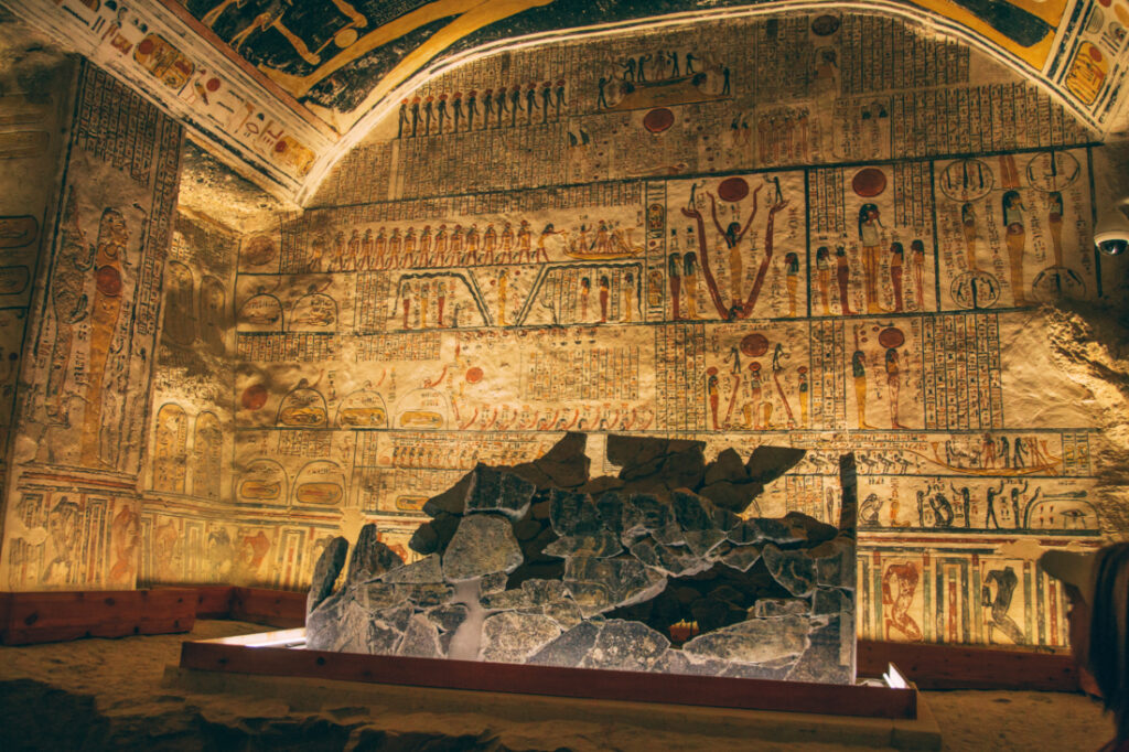 Remnants of the sarcophagus where King Ramses V was buried, surrounded by stone walls covered with ancient carvings.