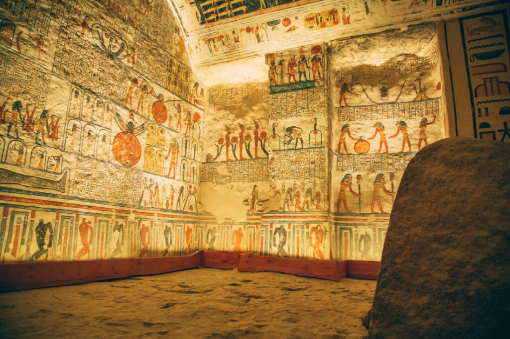A room inside the tomb of King Ramses V, where the walls are completely covered with ancient Egyptian carvings and hieroglyphs. 