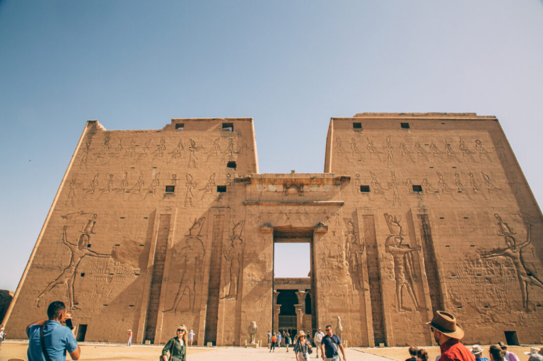 A picture of the Temple of Horus at Edfu in Egypt with tourists walking around and taking pictures. 