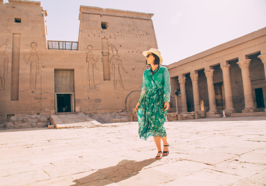 Author wearing a green maxi dress along with a camel bone necklace with Philae Temple in the background. 