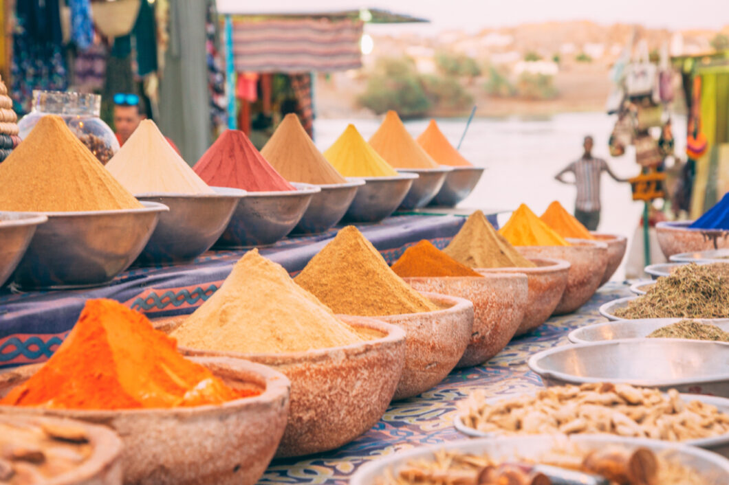Rows of bowls filled with spices and herbs line the shelves of a street vendor  stall in the Nubian Village.