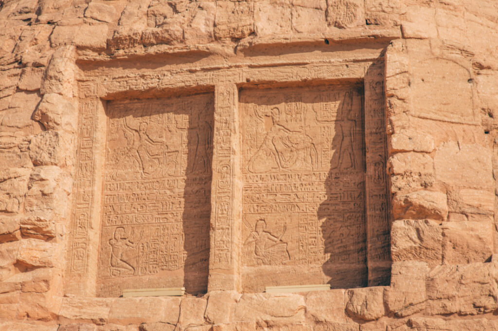 Stone windows covered with stone panels carved into the side of the Abu Simbel temple.