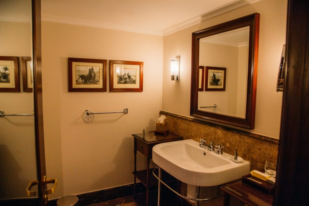 The bathroom of a suite at the Mena House features a pedestal sink and mirror along one wall.