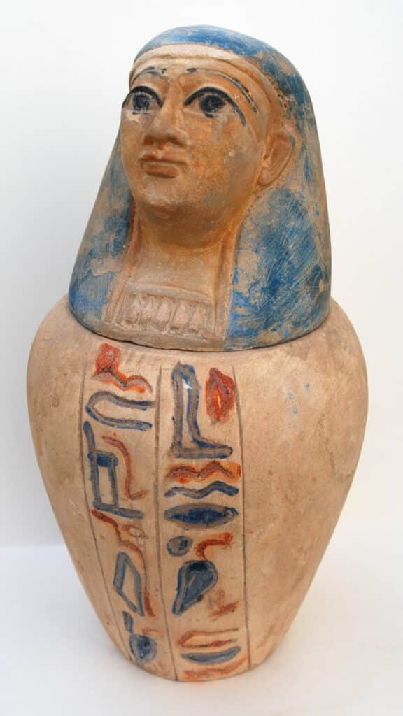 A handmade Egyptian canopic jar set against a white background