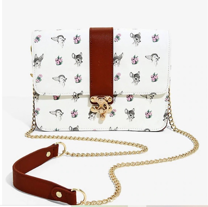 A small novelty handbag with Bambi characters on a white background. The bag has a gold clasp and gold cross-body chain with a leather strap.