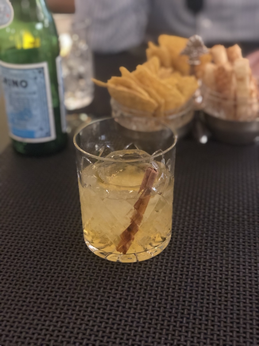 The A Gentleman in Moscow cocktail, served at a bar inside the Metropol Hotel in Moscow. The cocktail is made inside a highball glass with an ice sphere and cinnamon stick.