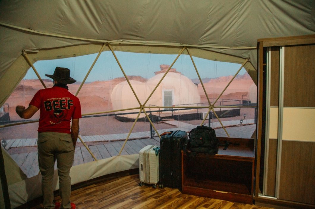 Mazayen Rum Camp Review - a Wadi Rum Luxury Desert Camp (with Martian Tents!) A man wearing hat watching outside from the camp.