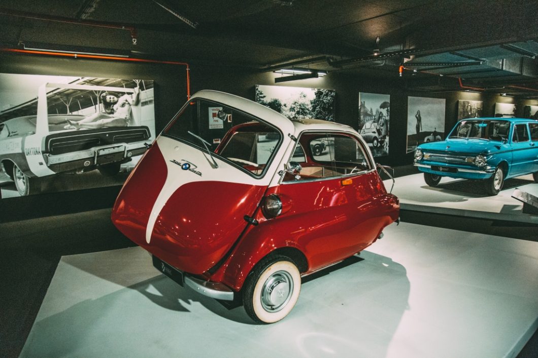 A small red and white 1958 BMW Isetta microcar on display at the Heydar Aliyev Center's Classic Car Exhibit in Baku, Azerbaijan