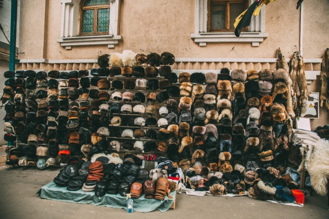 A street display of Russian fur hats for sale on the streets of Moscow. Hundreds of Ushanhas are lined in rows and stacked on the ground.