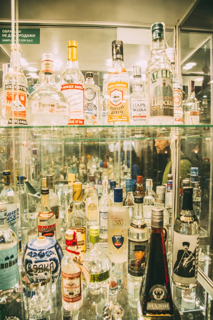 Two glass display shelves filled with Russian vodka bottles.