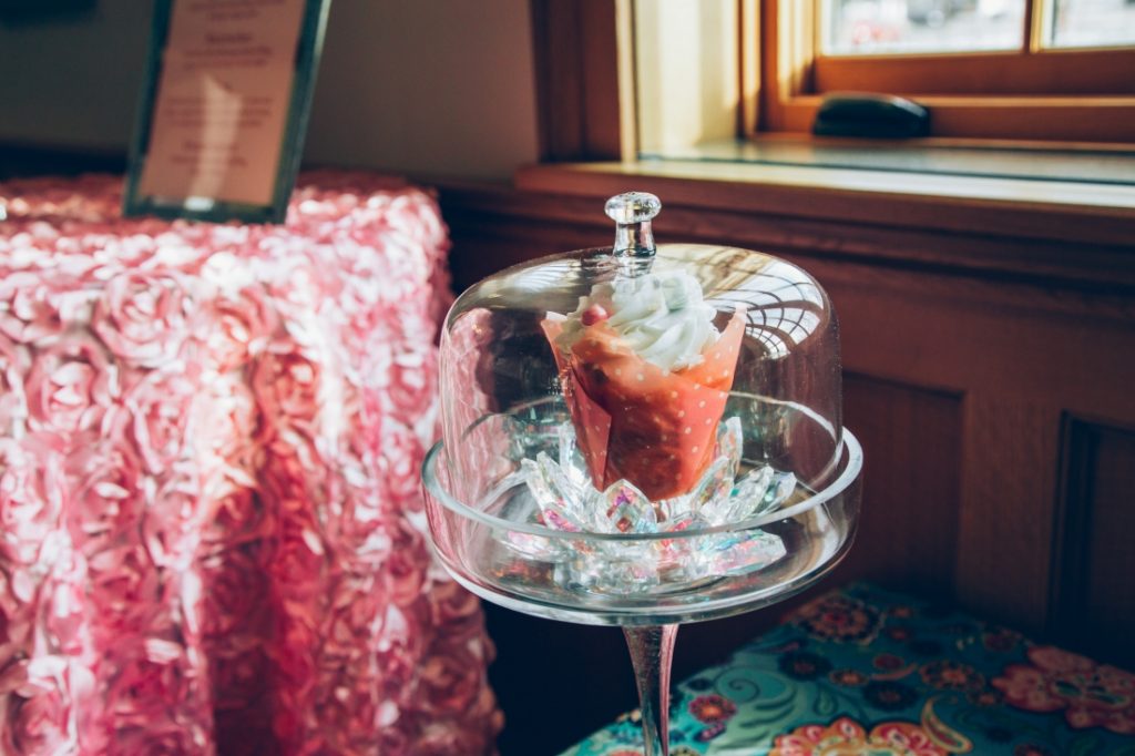 The Sugar Plum Fairy cupcake displayed in a glass dessert case.