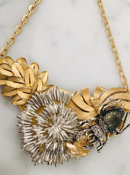 Gorgeous collage, original by artist. Midcentury vintage pieces form a stunning unique collage of dangerous beauty. A stag beetle approaches a lovely starflower in a garden. 22ct goldplate chain.