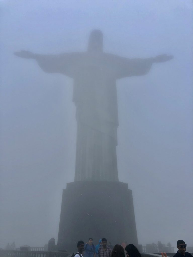 A hazy, foggy photo of the Christ the Redeemer statue obscured by fog and mist.