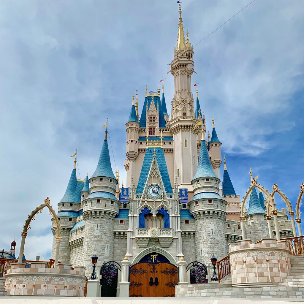 A professional photo of Cinderella's Castle at Disney World against a clear blue sky with light clouds.