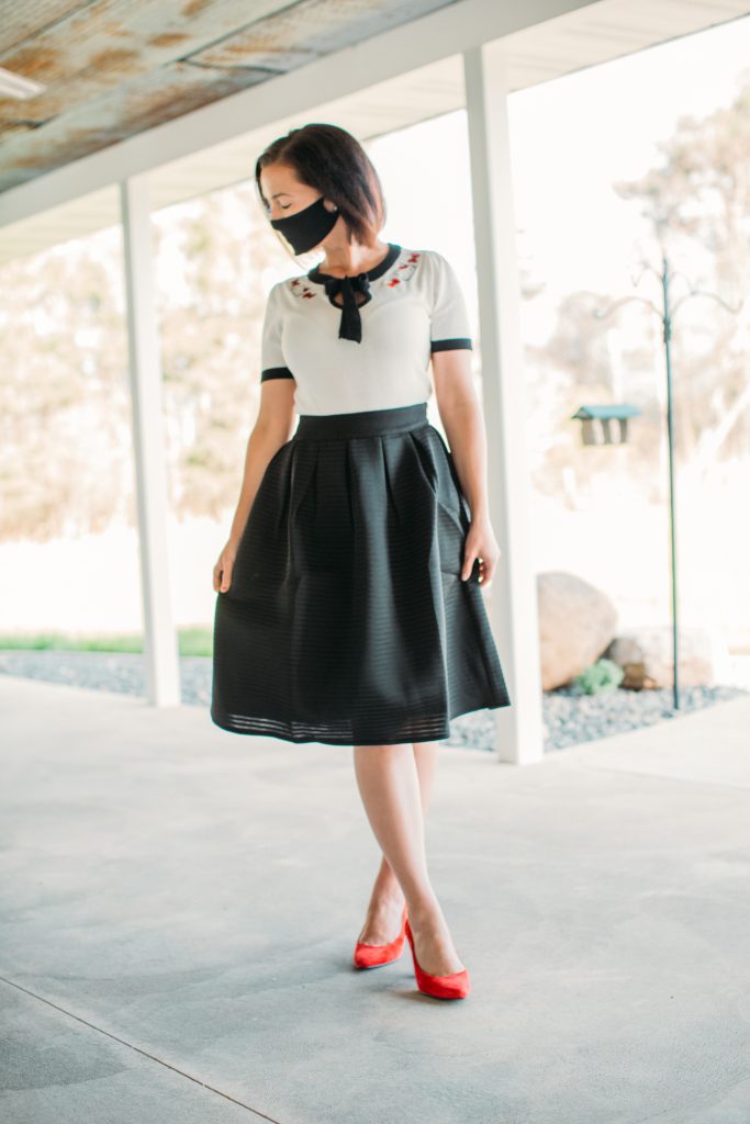 Wearing a cloth face mask with a black midi skirt by Pocket Passionista