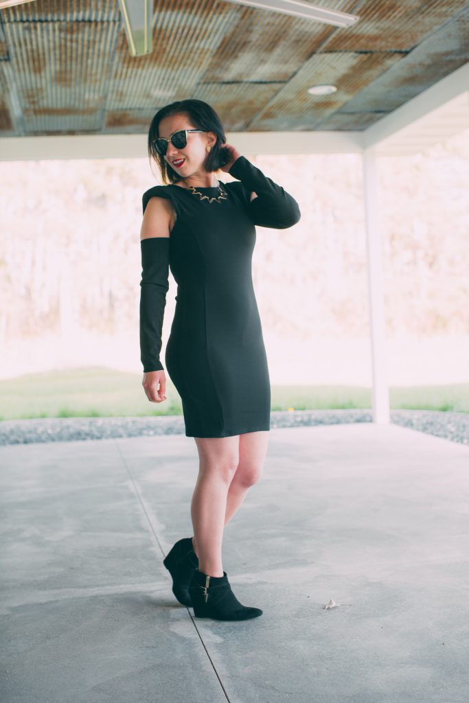 black dress with padded shoulders and cut out sleeves 