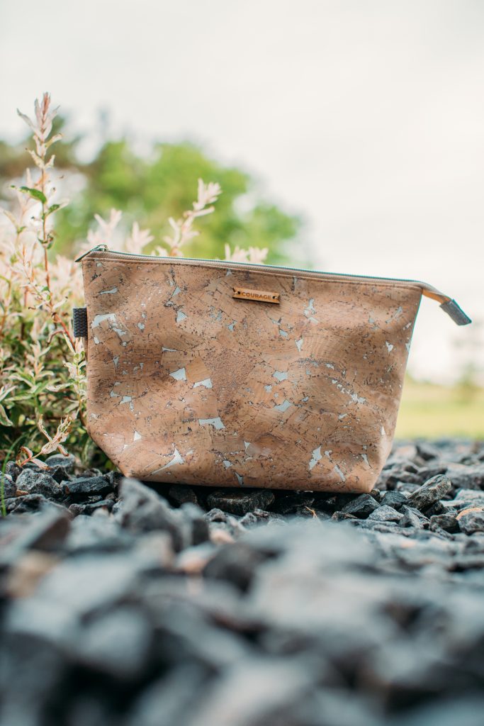 A sustainably made makeup bag fashioned from a durable cork material from the sustainable brand Carry Courage.