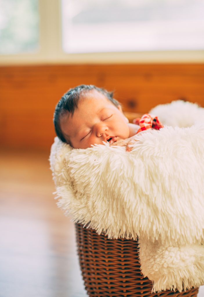 Newborn photo of Claire in a basket with fluffy blanket