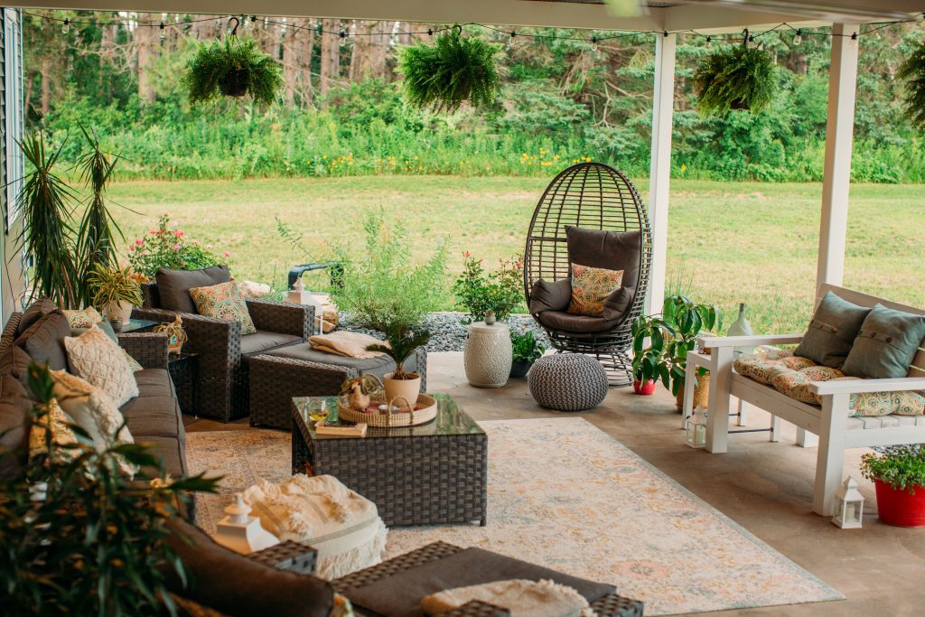 Backyard living comfortable boho chic outdoor living space with wicker furniture, ferns, egg chair