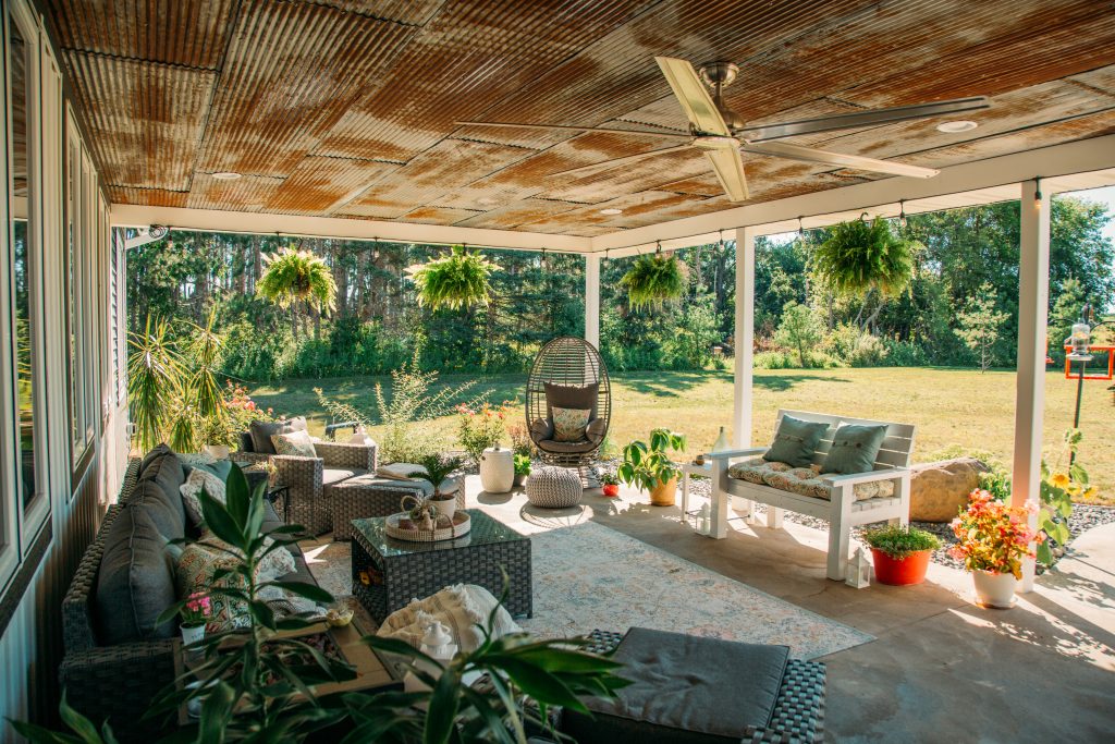 Boho chic outdoor living space with hanging boston ferns and air plants